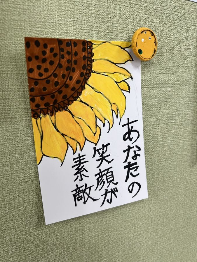 ひまわりの絵と「あなたの笑顔が素敵」の書